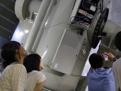 シュミット望遠鏡を見上げる生徒